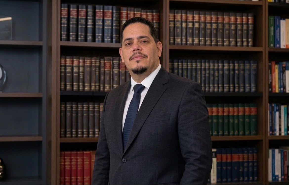 Marcelo Reategui diante de estante de livros jurídicos